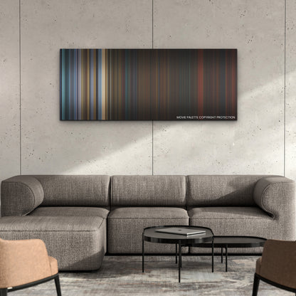 Saw X color palette canvas on a concrete wall above a gray sectional sofa