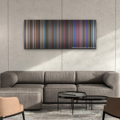 Elvis color palette canvas on a concrete wall above a gray sectional sofa