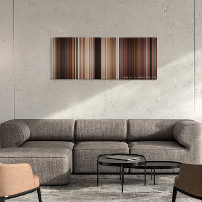 Maverick color palette canvas on a concrete wall above a gray sectional sofa