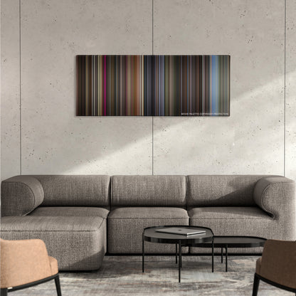 The Gentlemen color palette canvas on a concrete wall above a gray sectional sofa
