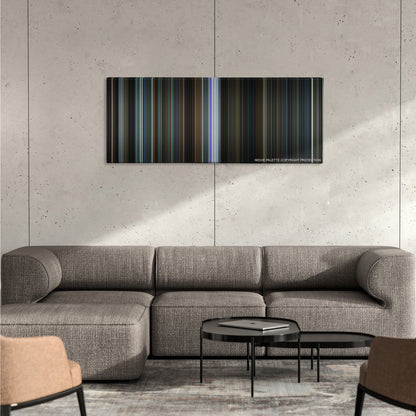 Now You See Me 2 color palette canvas on a concrete wall above a gray sectional sofa