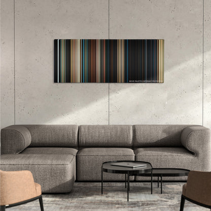 I Am Number Four color palette canvas on a concrete wall above a gray sectional sofa