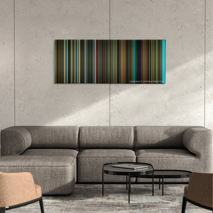 Revolver color palette canvas on a concrete wall above a gray sectional sofa