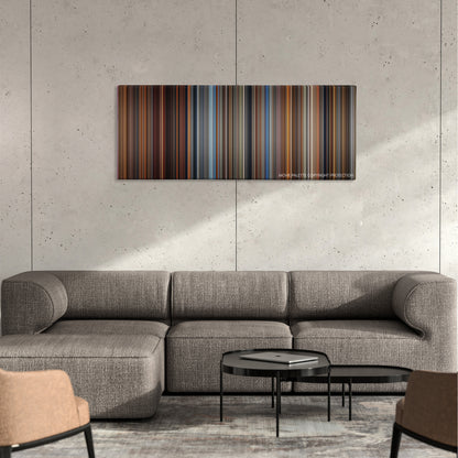 Malcolm X color palette canvas on a concrete wall above a gray sectional sofa