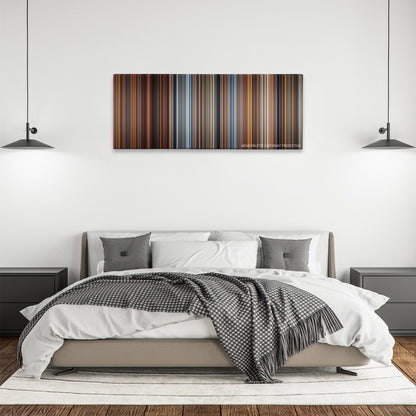 Malcolm X color palette canvas above a bed, between two black pendant lamps