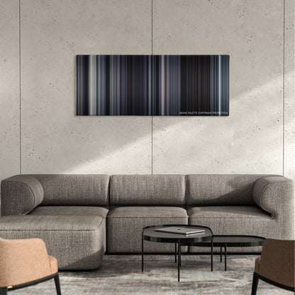 Martyrs color palette canvas on a concrete wall above a gray sectional sofa
