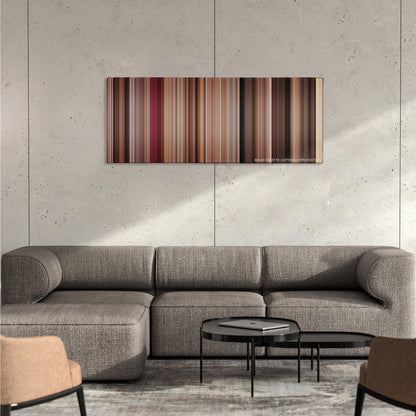 27 Dresses color palette canvas on a concrete wall above a gray sectional sofa