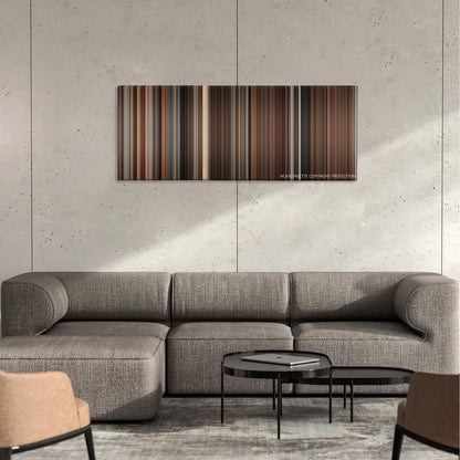 Bloodsport color palette canvas on a concrete wall above a gray sectional sofa