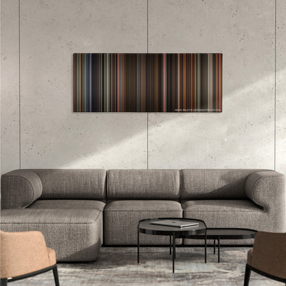 The Greatest Showman color palette canvas on a concrete wall above a gray sectional sofa