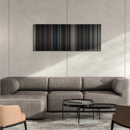 The Dark Knight Rises color palette canvas on a concrete wall above a gray sectional sofa