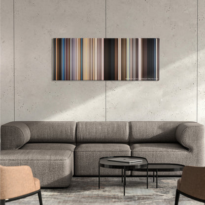 We're the Millers color palette canvas on a concrete wall above a gray sectional sofa