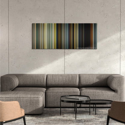 Sicario color palette canvas on a concrete wall above a gray sectional sofa