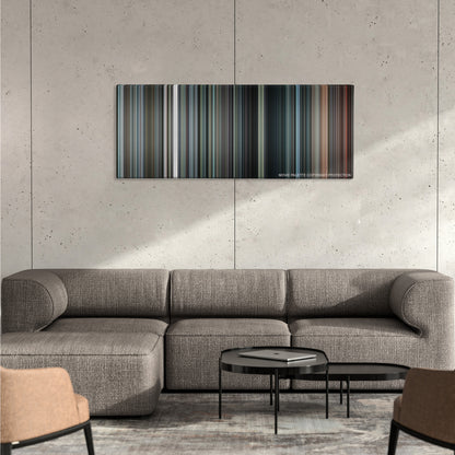 Inside Man color palette canvas on a concrete wall above a gray sectional sofa