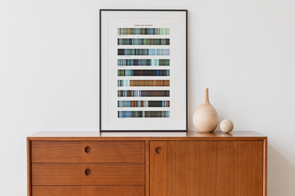 Squid Game Season 1 color palette print, framed on a wooden sideboard — one color strip per episode